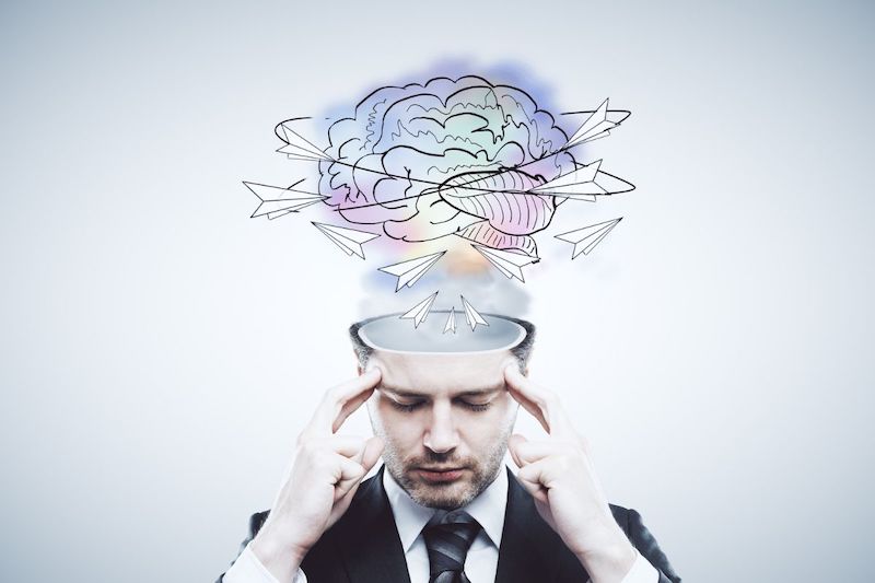 photo of a lobotomized man rubbing his temples, with an illustration above his head of paper airplanes swirling around his brain